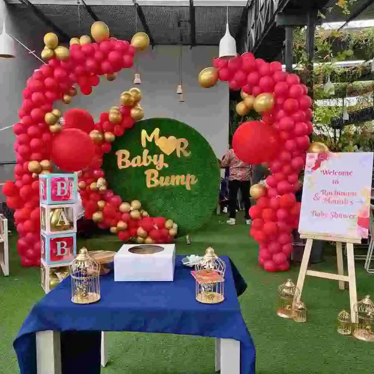 Book red and gold baby shower decoration with a floral backdrop