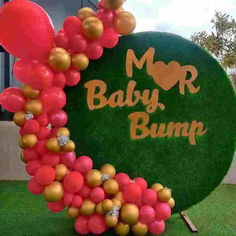 Red and gold baby shower decoration with floral backdrop