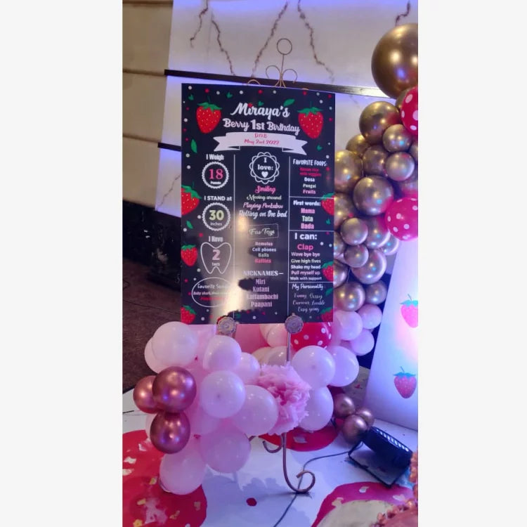 Book Berry First Birthday Decor with personalized strawberry-themed birthday welcome board and balloon decorations