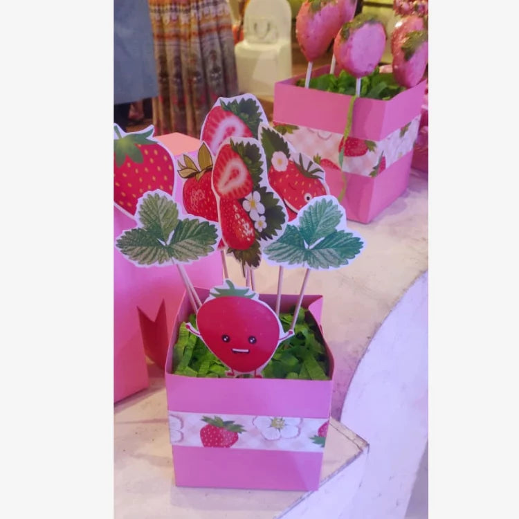 Get Berry First Birthday Decor with strawberry-themed table props and fruit decorations
