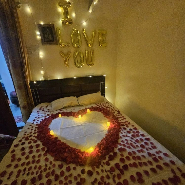 Book wedding night bed decoration with rose petals, heart design and candles