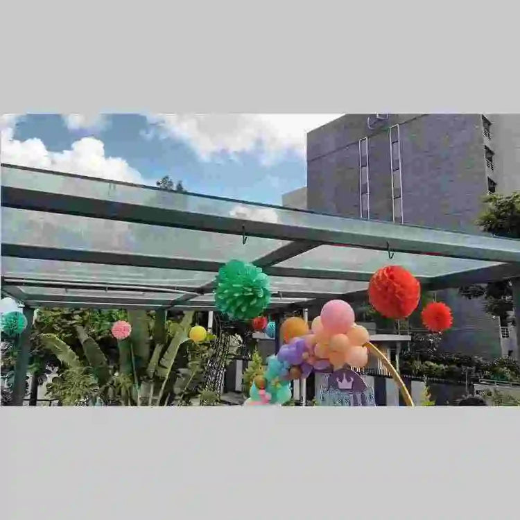 order pastel birthday venue decor with hanging pom poms and balloons