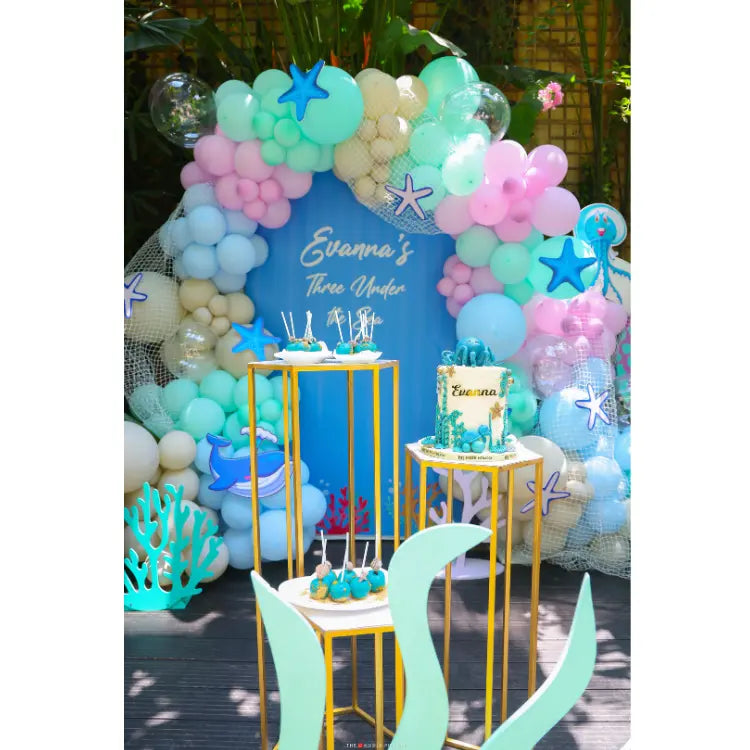 Get Under the Sea Birthday Decor with colorful balloon backdrop, ocean props and themed cake table setup