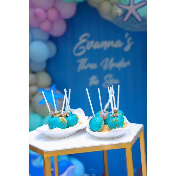 Get Under the Sea Birthday Decor with ocean-themed cake pops and birthday backdrop