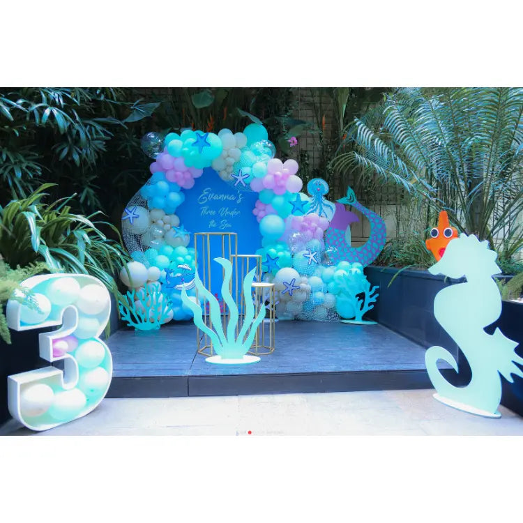 Book Under the Sea Birthday Decor with ocean-themed balloon arch, sea animal cutouts and themed stage setup