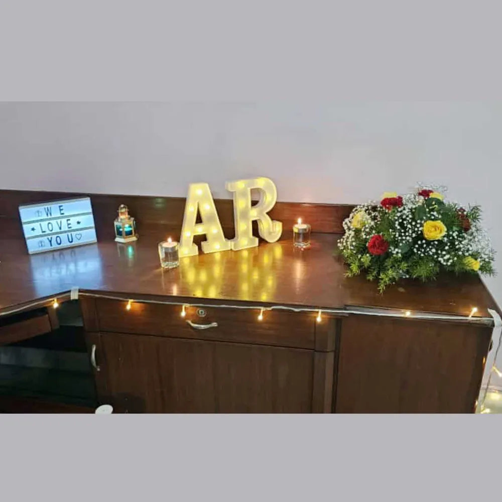 Book Welcome Couple Decor at Home with floral bouquet, marquee lights and t-light candles